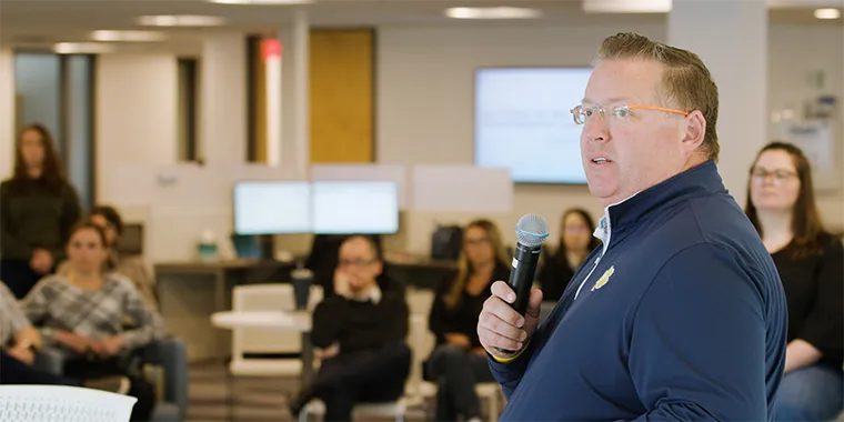 Team member speaking into a microphone at an office gathering